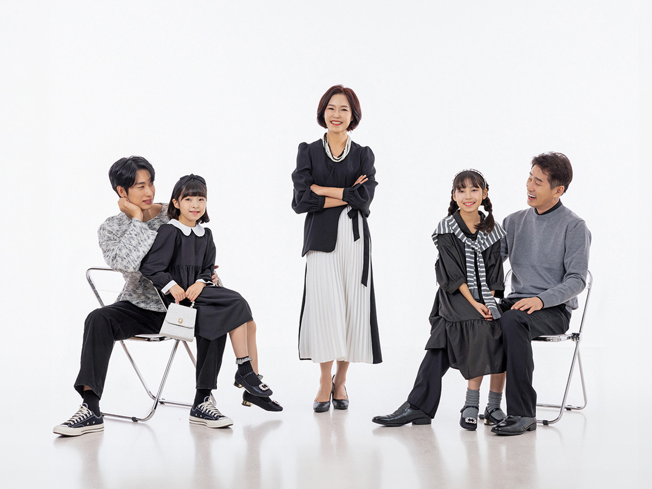 신부가 한송이 꽃을 들고 앉아 신랑과 같이 환하게 웃는 웨딩사진