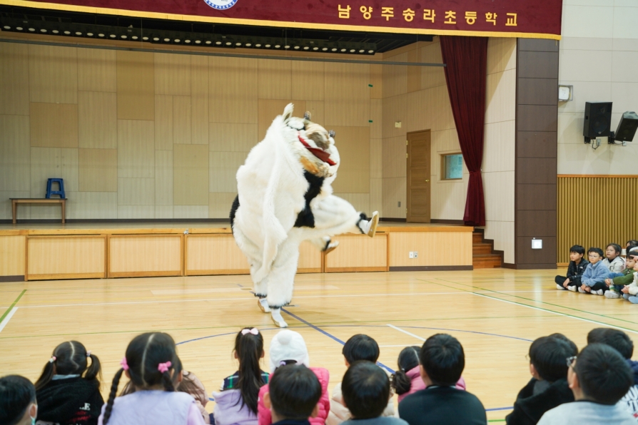 유치원공연 풍물마당놀이 해피에서 사자탈 연희자가 역동적인 동작을 선보이는 장면