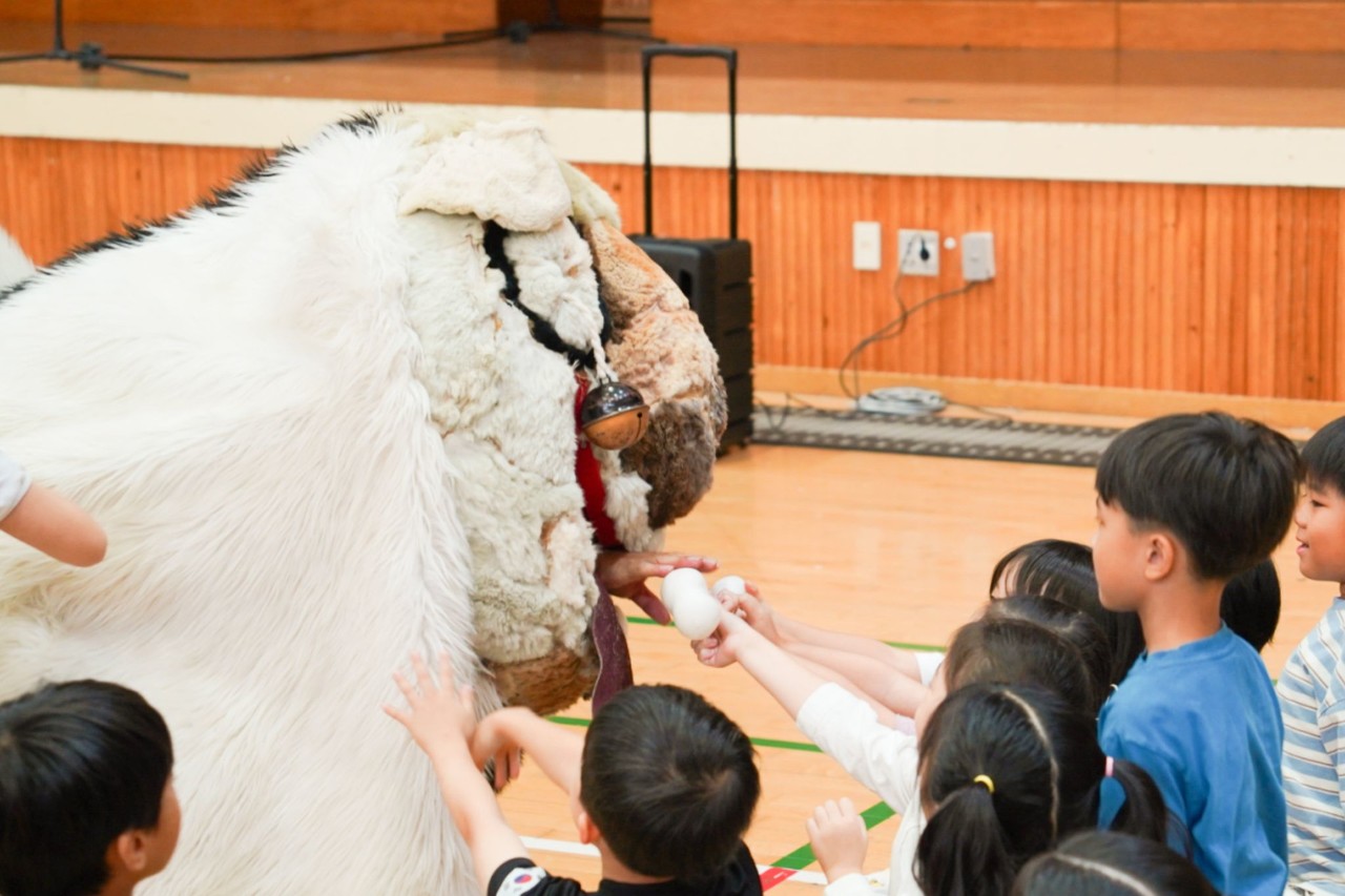 유치원 원아들이 강아지탈 해피에게 뼈다귀 소품을 건네며 직접 참여하는 체험형 전통공연 풍물마당놀이 해피 현장