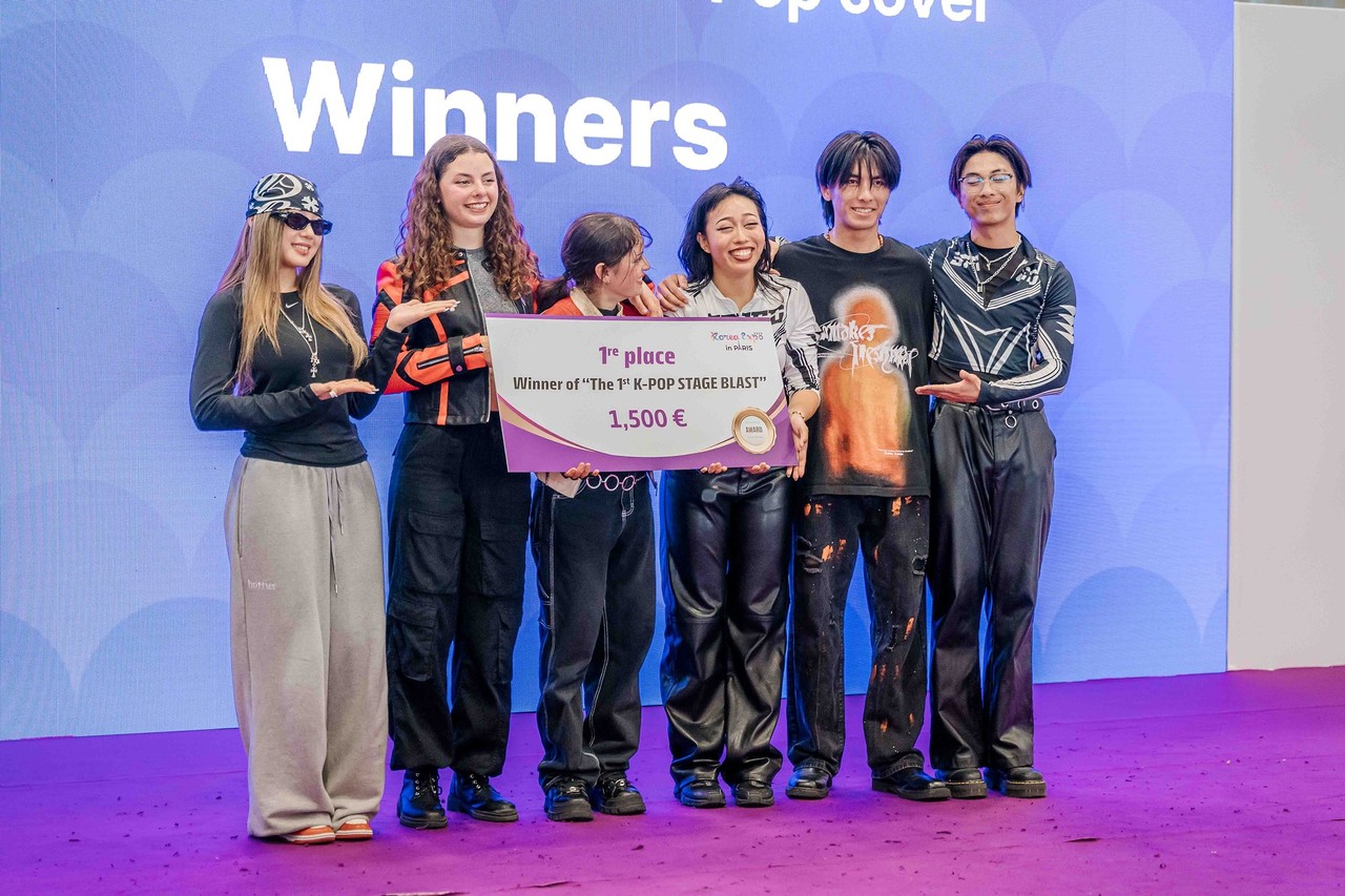 The winning group of a K-Pop dance competition on the Main Stage, posing with the prize check during the Korea Expo