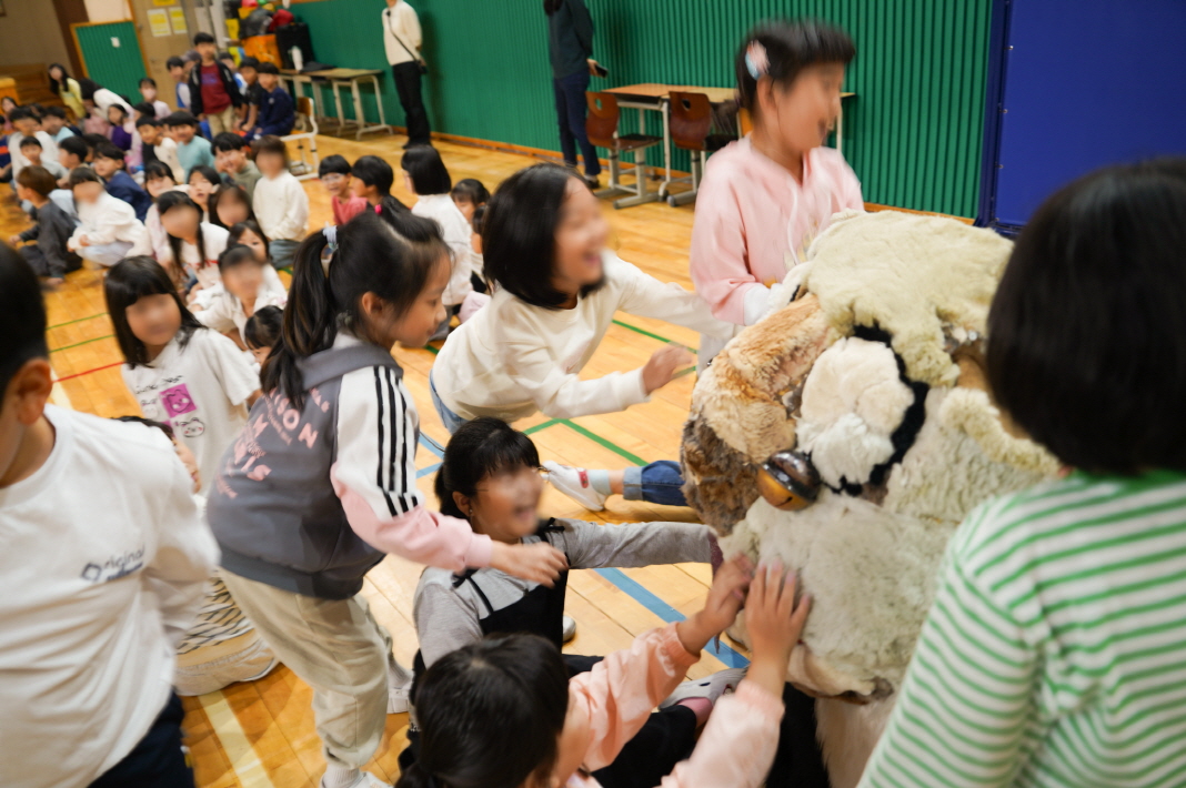 풍물마당놀이 해피 공연에서 아이들이 전통 사자탈을 직접 만지며 참여하는 유치원 전통연희 공연 장면