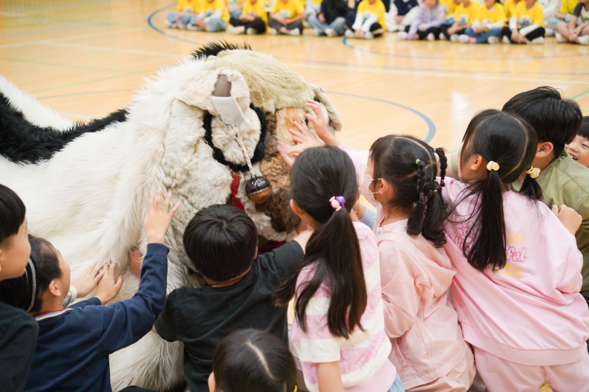 아이들이 해피 캐릭터를 만지며 즐거워하는 풍물마당놀이 해피 공연 현장