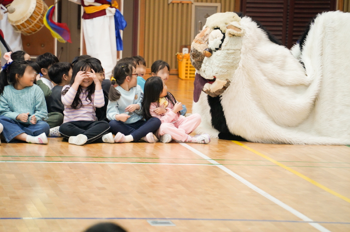 유치원 풍물마당놀이 해피 공연에서 아이들과 눈높이로 상호작용하는 장면
