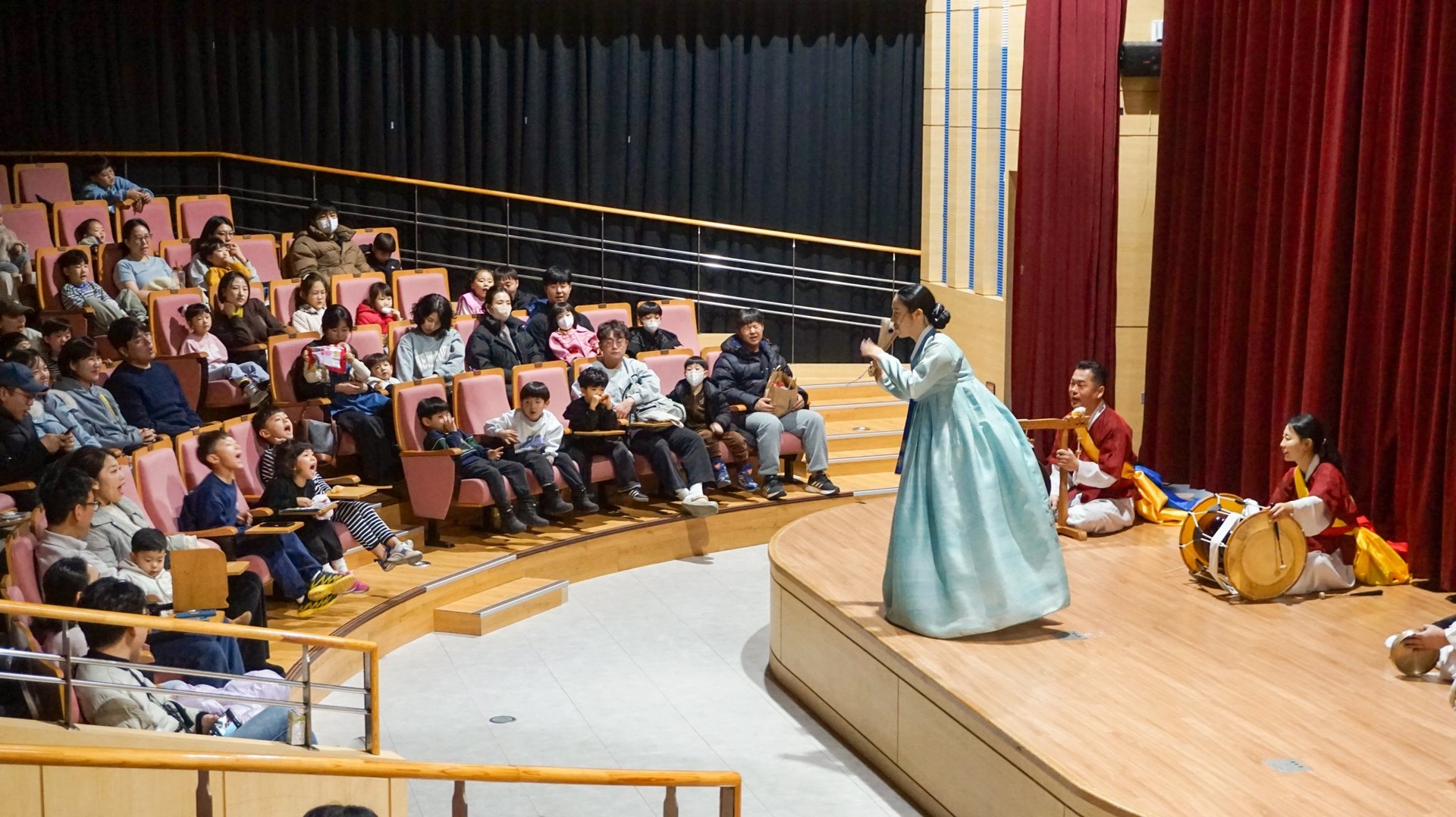 소리꾼의 구성진 민요 소리에 맞춰 합굿마을 연주단이 사물 가락을 더하고, 어린이 관객들이 신기한 듯 무대를 집중해서 바라보는 모습