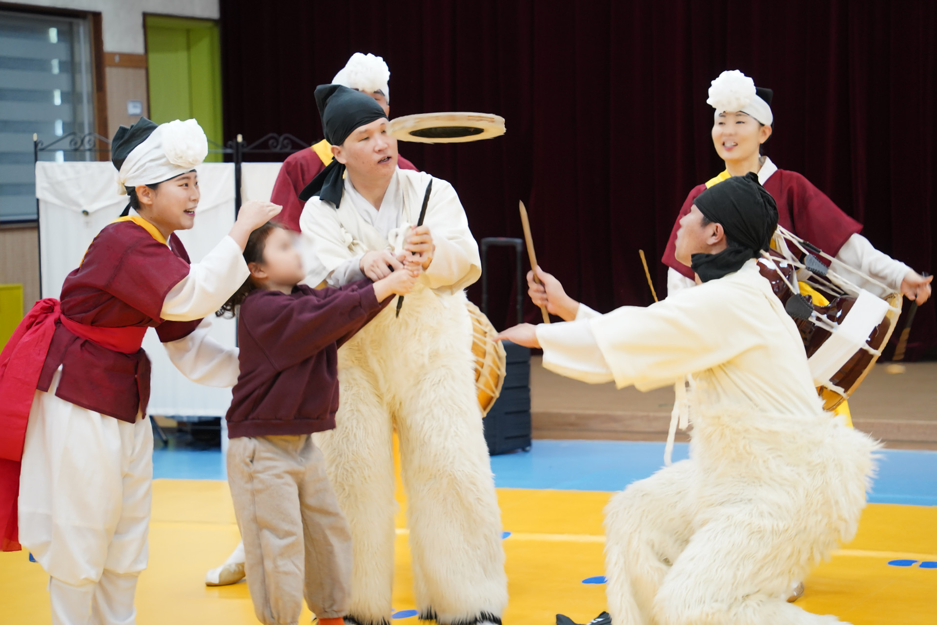 공연의 하이라이트인 버나놀이 체험 중, 한 어린이가 무대 위로 올라와 합굿마을 출연자의 도움을 받으며 직접 버나를 돌려보는 모습. 관람을 넘어 아이들이 직접 주인공이 되는 쌍방향 소통 공연의 현장
