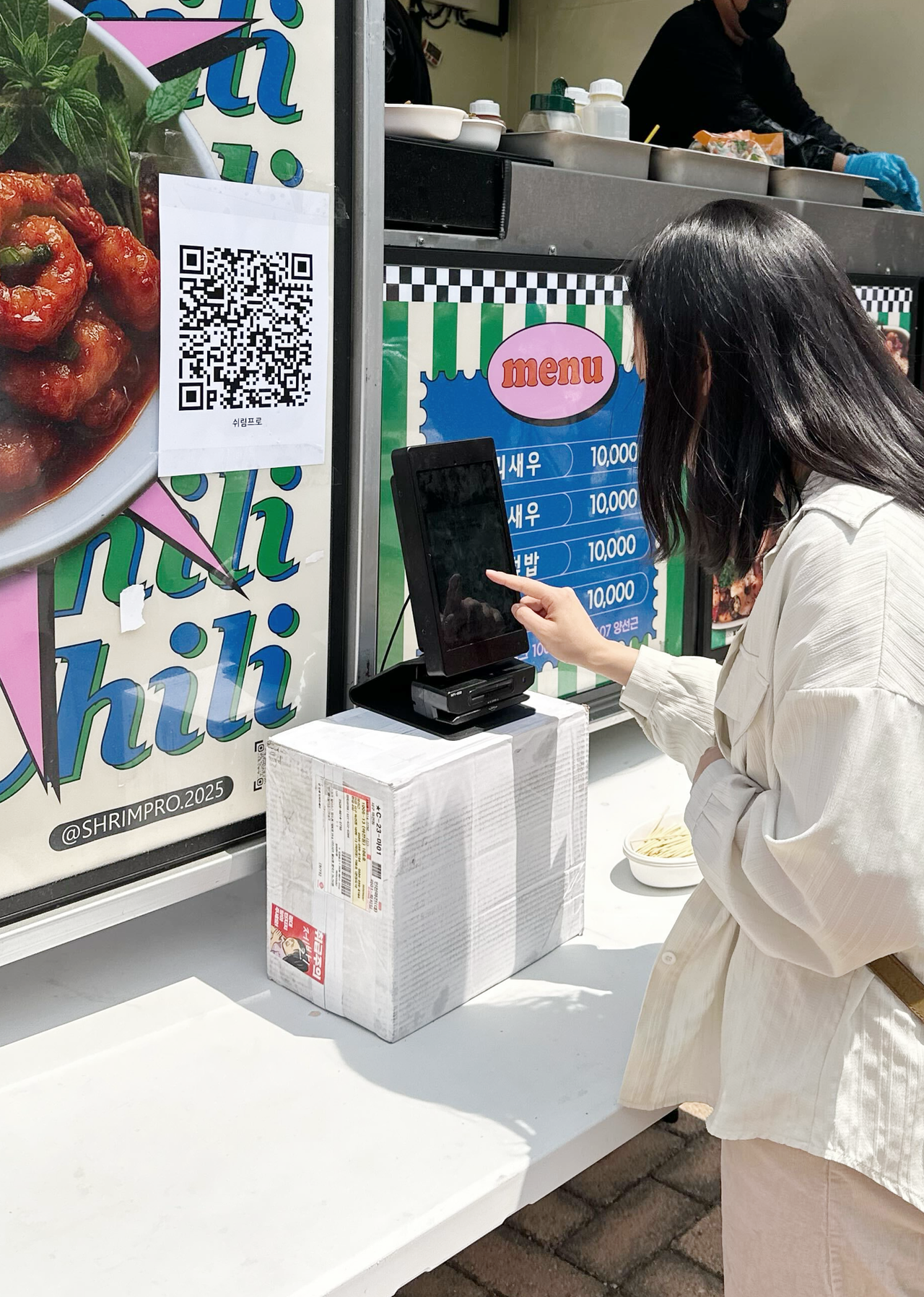 푸드트럭에 부착된 메이트 행사결제솔루션 QR 포스터로 주문하는 손님