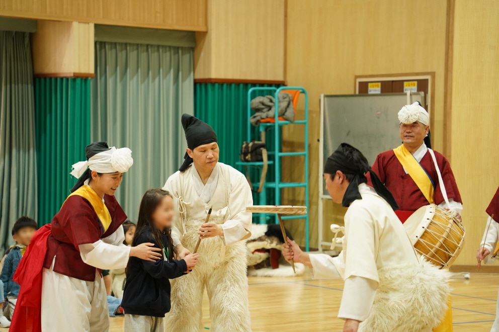 합굿마을 공연단원의 도움으로 목포 부주초 병설유치원 어린이가 전통 버나놀이 접시돌리기를 직접 체험하는 장면