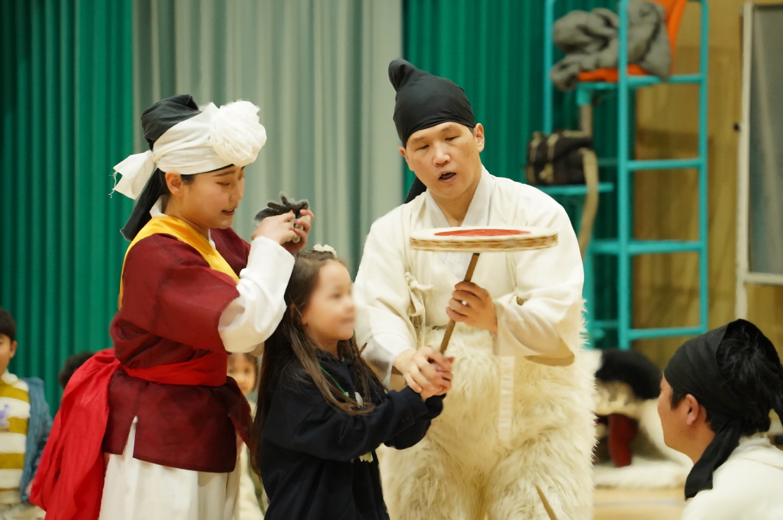 합굿마을 공연단원이 목포 부주초 병설유치원 어린이에게 전통 버나놀이(접시돌리기) 체험을 지도하는 장면