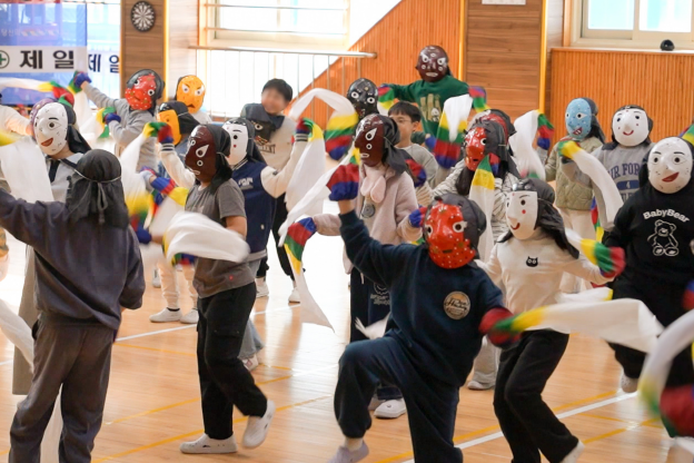 전주 금암초 강당에서 빨간 탈, 초록 탈, 흰 탈, 검은 탈을 쓴 아이들이 흰 한삼을 휘날리며 역동적으로 춤추는 합굿마을 K-POP 탈춤체험 현장