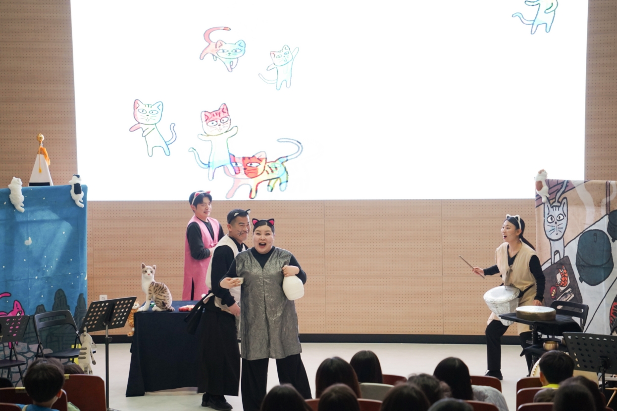 나는고양이로소이다 배우 4인 공연 장면 – 배경 스크린에 다채로운 고양이 일러스트 애니메이션이 펼쳐지는 합굿마을 세계명작동화 어린이마당놀이