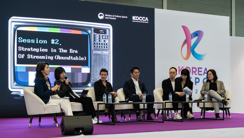 Panel discussion at Korea Expo with speakers seated on stage during a K-culture session