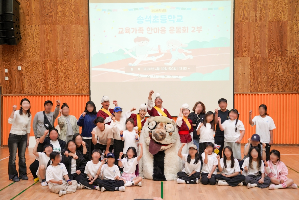 서천 송석초등학교 학생들과 학부모, 선생님들이 합굿마을 마당놀이 공연을 관람한 후 강아지 탈 해피, 풍물단원들과 단체 기념 촬영을 하고 있다