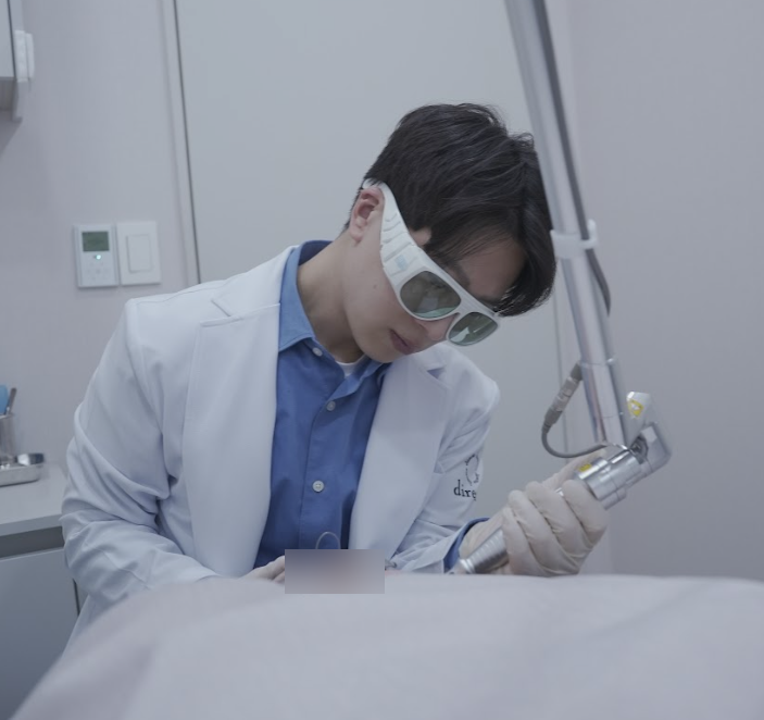 디렉터의원 원장이 보호 안경을 착용하고 레이저 장비로 시술을 진행하는 모습