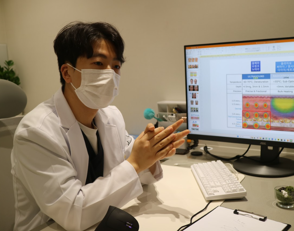 디렉터의원 원장이 모니터의 장비 정보 자료를 보며 환자에게 설명하는 진료 상담 모습