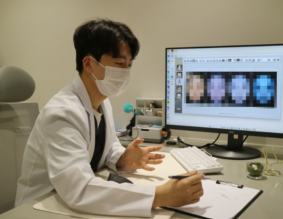 디렉터의원 원장이 피부 분석 화면을 보며 진단 내용을 메모하고 설명하는 모습