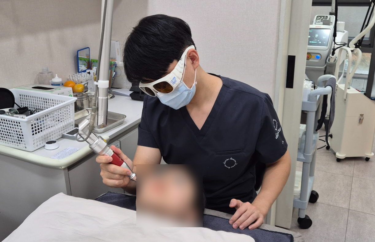 디렉터의원 원장이 보호 안경을 착용하고 환자에게 레이저 시술을 진행하는 모습