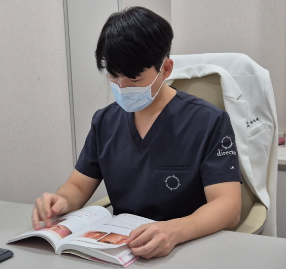 디렉터의원 원장이 진료실에서 의학 자료를 검토하는 모습