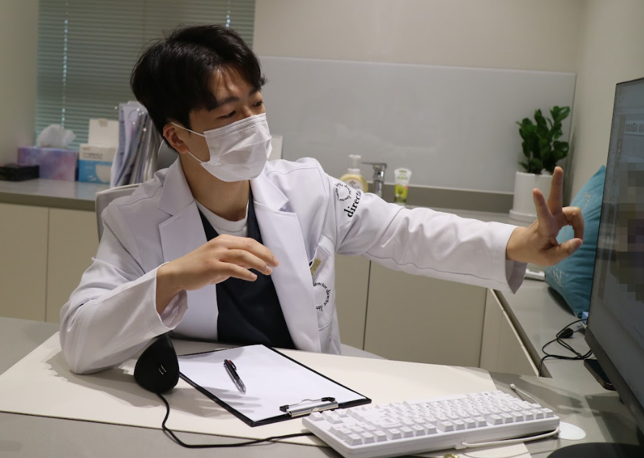 울산흉터치료 상담 시 모니터로 피부 상태를 설명하는 디렉터의원 원장 사진