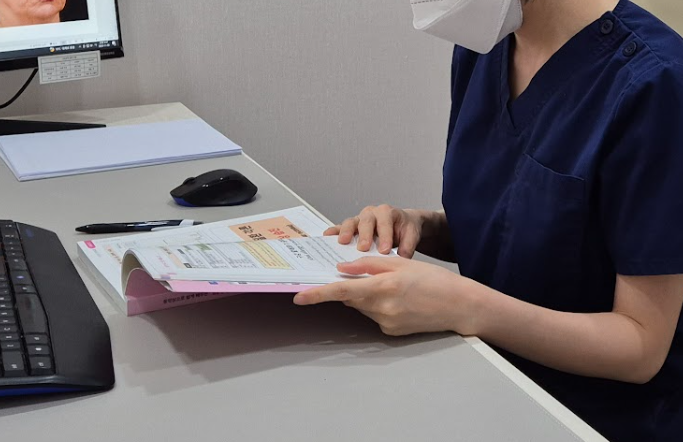 강남점빼기 시술 안내 자료를 검토하는 의료진 진료 준비 사진