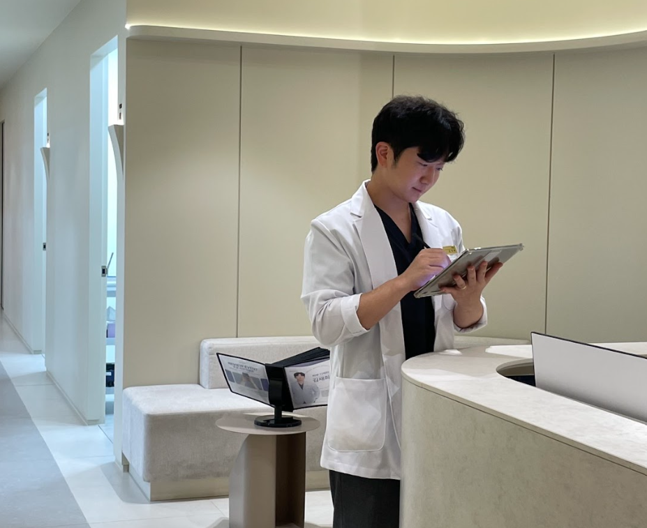 대전유성구피부과 디렉터의원 원장이 진료 자료와 서적을 검토하는 사진