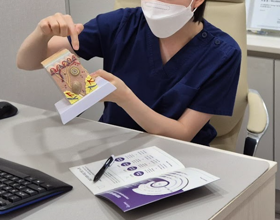 강남점빼기 상담 시 피부 구조 자료로 설명하는 의료진 사진