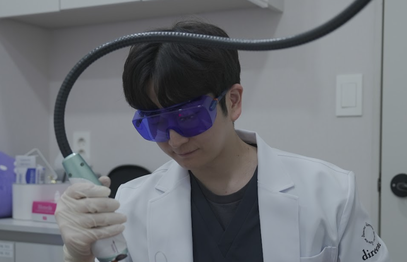 대전레이저제모 레이저 핸드피스를 들고 시술 부위를 조준하는 의료진 사진