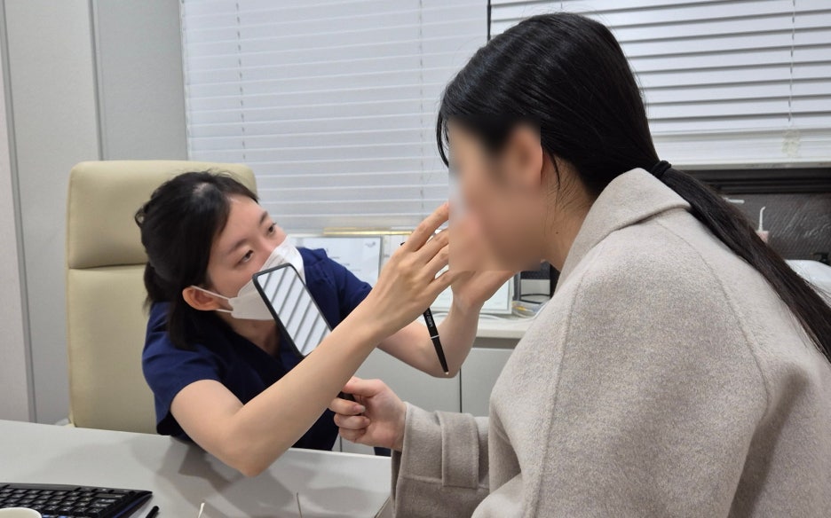 천호리프팅 상담에서 얼굴 라인을 확인하며 턱선리프팅 시술 부위를 설명하는 의료진