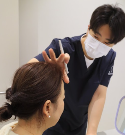 디렉터의원 의료진이 고객의 얼굴 비율과 피부 상태를 분석하며 1:1 맞춤 디자인 상담을 진행하는 모습