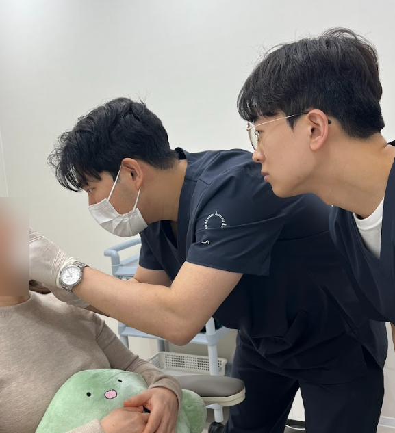 디렉터의원 의료진이 환자의 얼굴을 함께 분석하며 맞춤 리프팅 디자인을 계획하는 모습