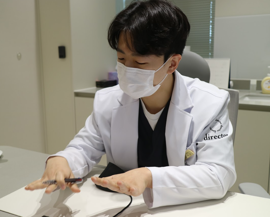 울산울쎄라 초음파가 근막층까지 도달하는 깊이를 손동작으로 설명하는 진료 상담 사진