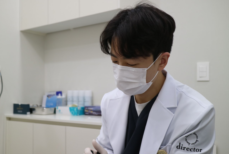 울산점빼기 시술 준비를 위해 원장이 진료실에서 장비를 살피는 모습 사진