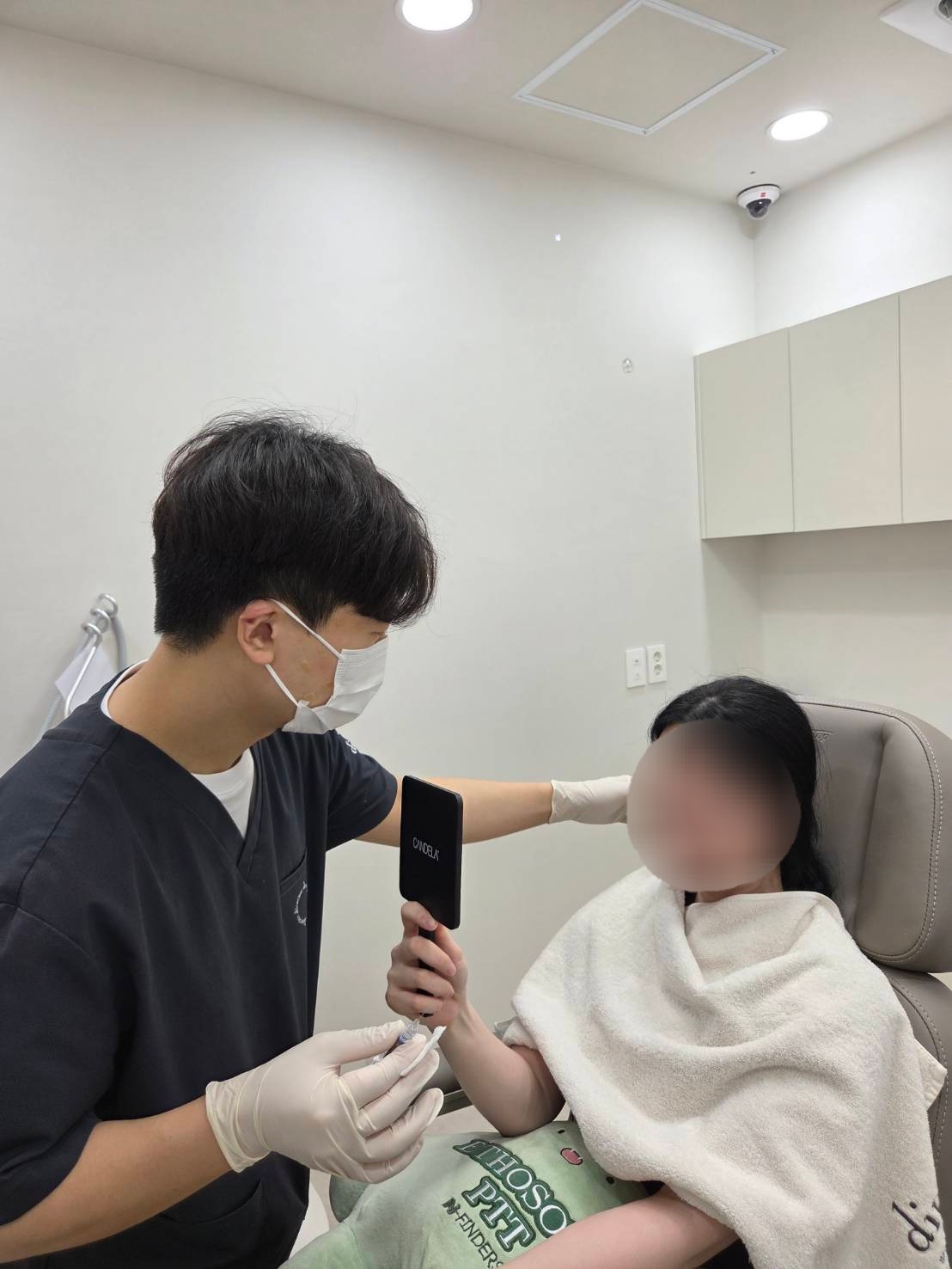 울산목주름 시술 전 원장이 거울로 시술 부위를 확인하며 설명하는 모습 사진