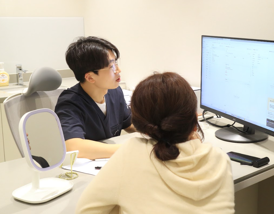 울산목주름 상담 시 원장이 모니터를 보며 주름 상태를 설명하는 모습 사진