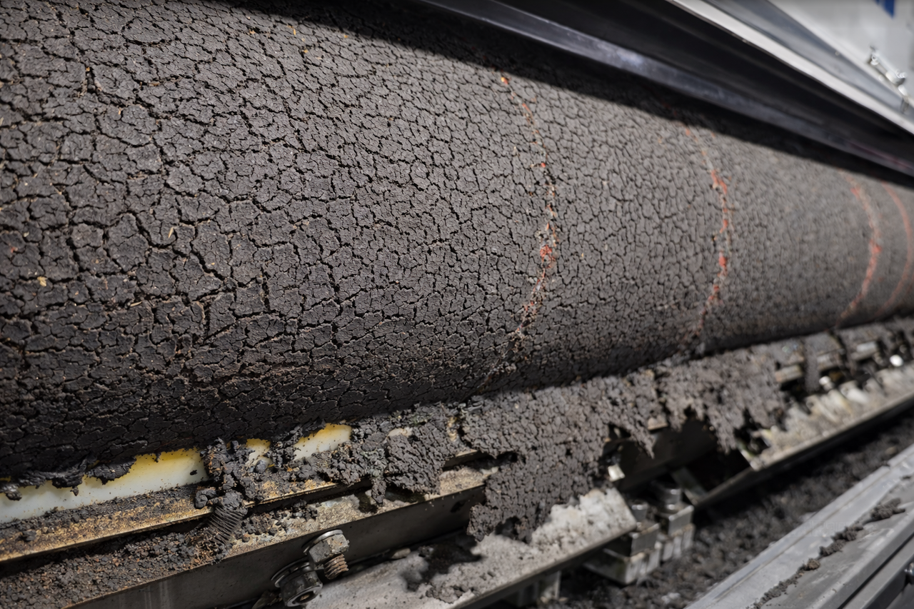 Close-up view of the dewatering process, showing machinery in operation, reducing moisture content in sludge