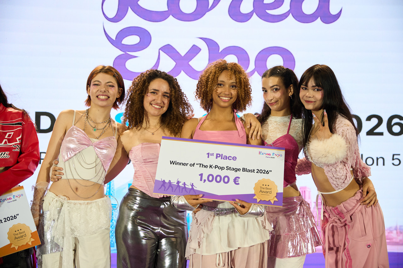 Le groupe vainqueur d'un concours de danse K-Pop sur la Scène Principale, posant avec le chèque de prix lors de la Korea Expo