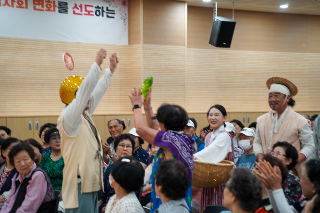 황금색 모자를 쓴 오복배달부가 관객에게 복을 전달하는 모습