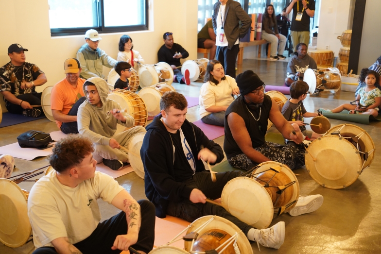 전주한옥마을 승암어울마당에서 바닥에 앉아 장구와 사물악기를 연주하는 주한미군과 가족들