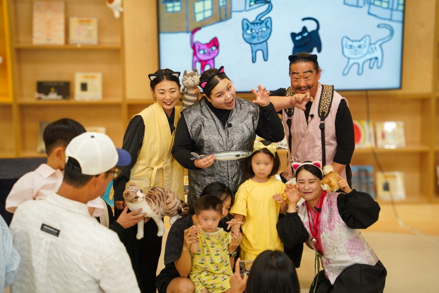엄마 품에 안긴 아이와 초등생 아이가 배우들과 기념촬영하는 모습