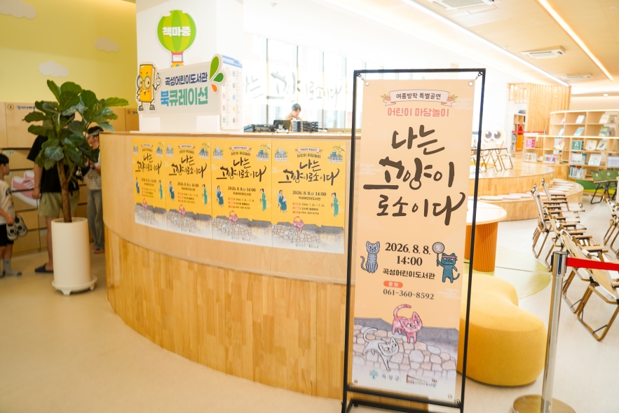 곡성어린이도서관 로비에 설치된 나는고양이로소이다 포스터와 배너, 여름방학 특별공연 마크가 찍혀있다