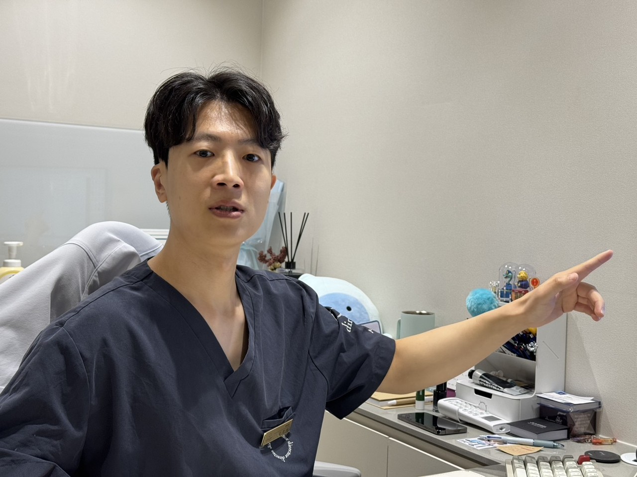 울산리쥬란힐러 설명하는 디렉터의원 원장, 진료실에서 손짓으로 안내하는 모습