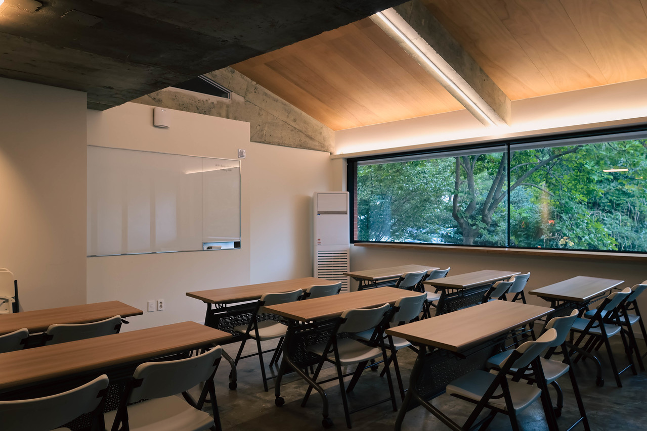 C302 소강의실. 창밖 숲이 보이는 강의형 책상 배치와 화이트보드