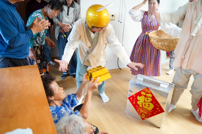 복 배달부가 전달한 금괴 모형의 재물복 선물을 받아 든 무주 치목마을 할머니