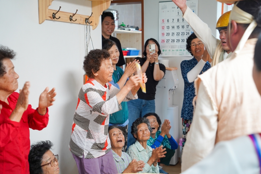 복 배달부가 전달한 장수를 상징하는 실타래 선물을 받아 든 무주 치목마을 할머니