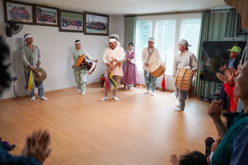 무주 치목마을회관에서 징과 장구, 북으로 고사소리를 반주하는 복이팡팡 공연단과 박수 치는 마을 어르신들