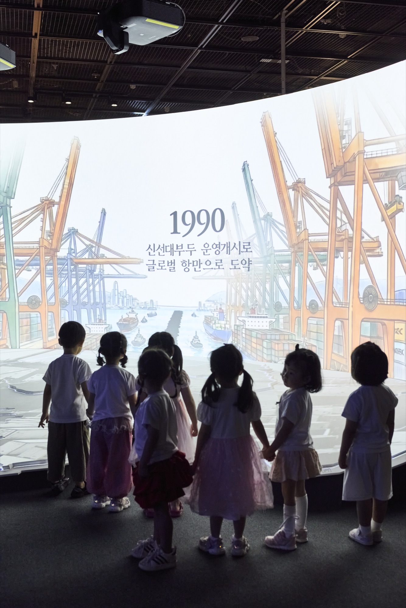1990 신선대부두 운영개시 영상 앞 어린이 관람객들.