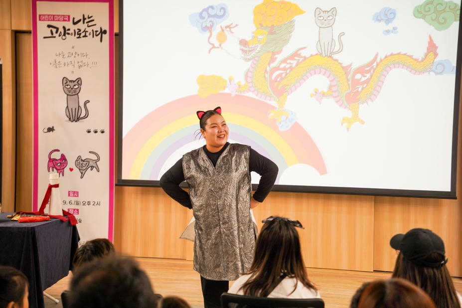 칠곡 석적도서관 어린이 공연 ‘나는 고양이로소이다’에서 고양이를 연기하는 배우와 애니메이션 무대 배경
