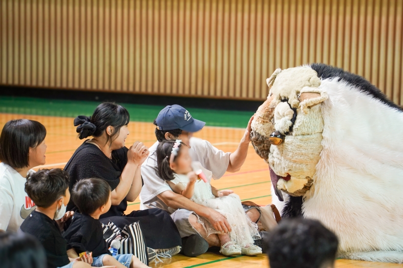 공주 어린이집 연합공연에서 강아지탈 해피를 쓰다듬는 아빠와 곁에서 바라보는 아이