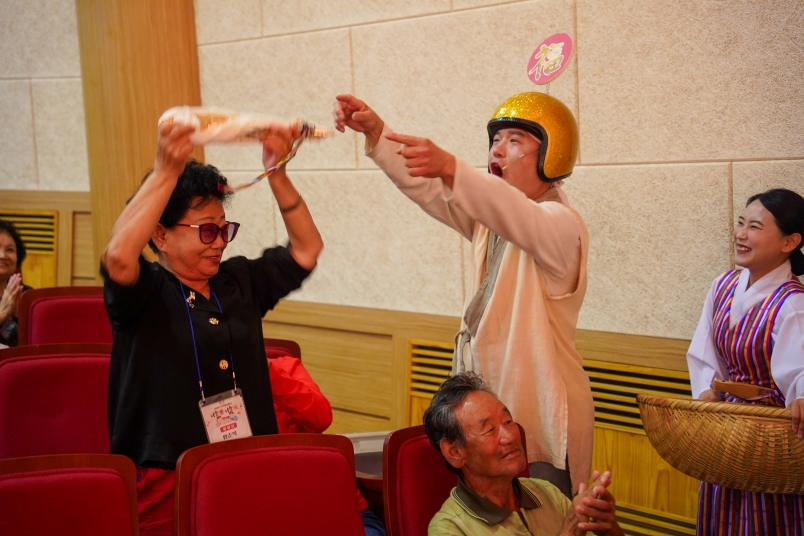 복배달부가 어르신에게 북어를 건네며 복을 나누는 모습