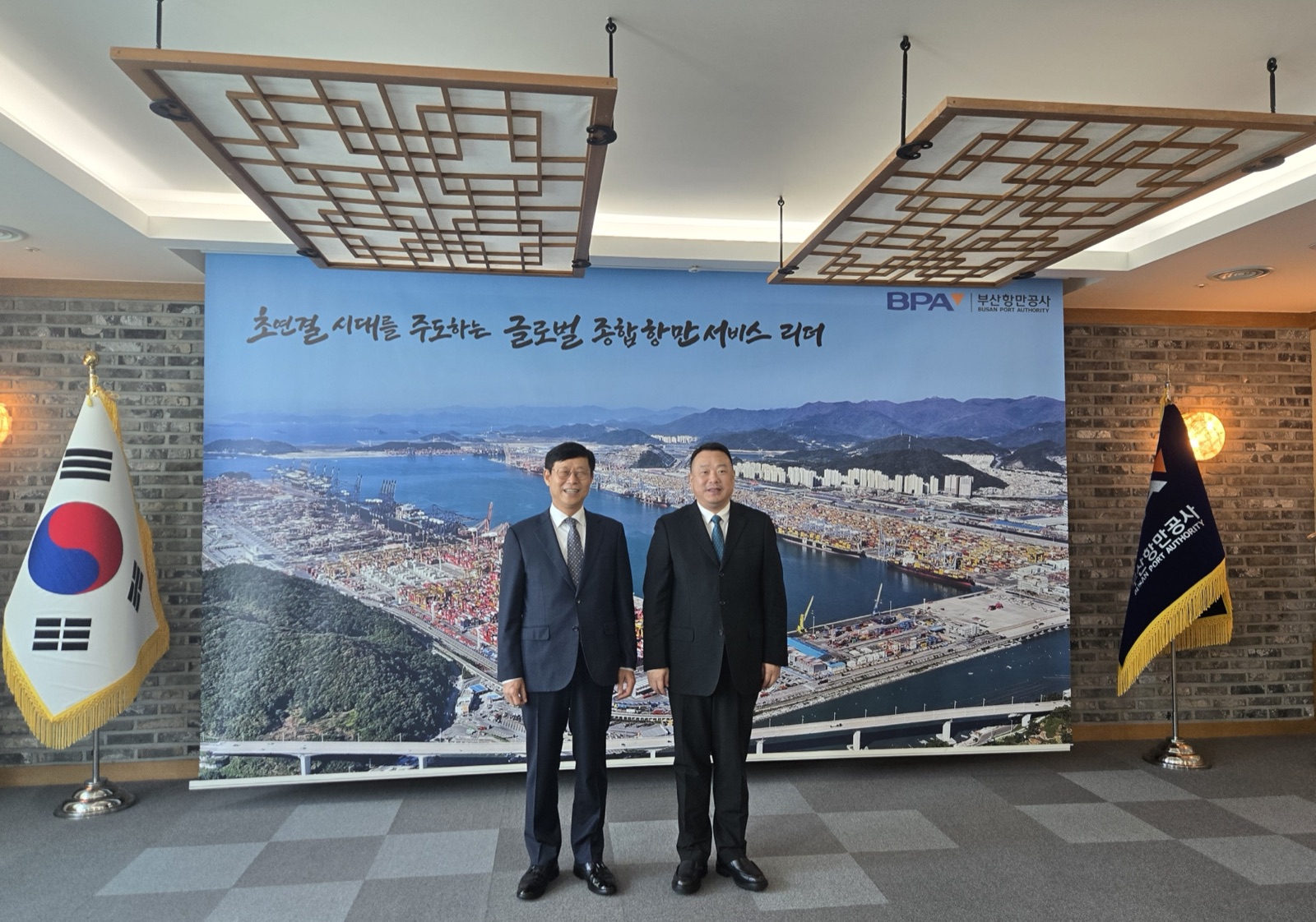 송상근 부산항만공사 사장과 주먀오 닝보저우산항만그룹 회장이 마주 서서 악수하며 인사를 나누는 모습