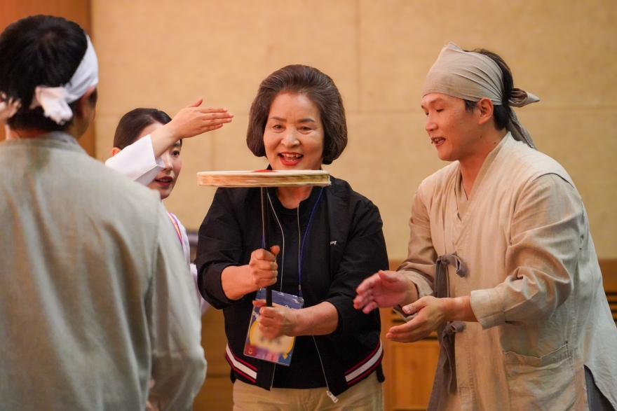 어르신이 직접 버나를 돌리며 버나놀이를 체험하는 모습